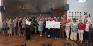 large group of people with a large check in the middle
