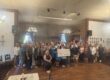 large group in restaurant holding check