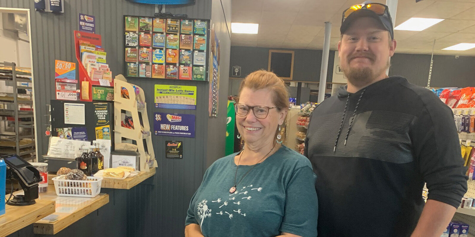 Woman and man with a grocery cart smiling at the checkout counter