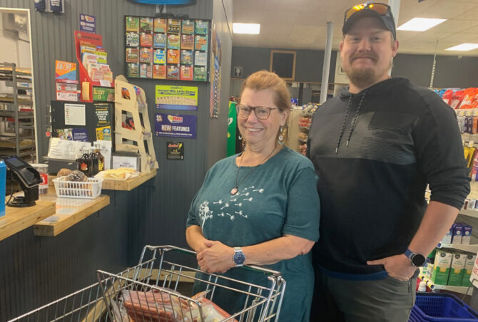 IMG_0759 Woman and man with a grocery cart smiling at the checkout counter