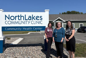 three women in front of sign outside