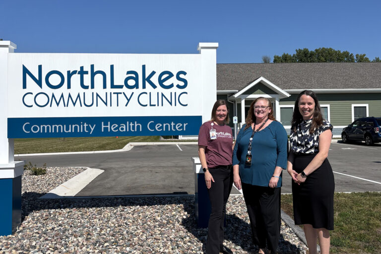 three women in front of sign outside