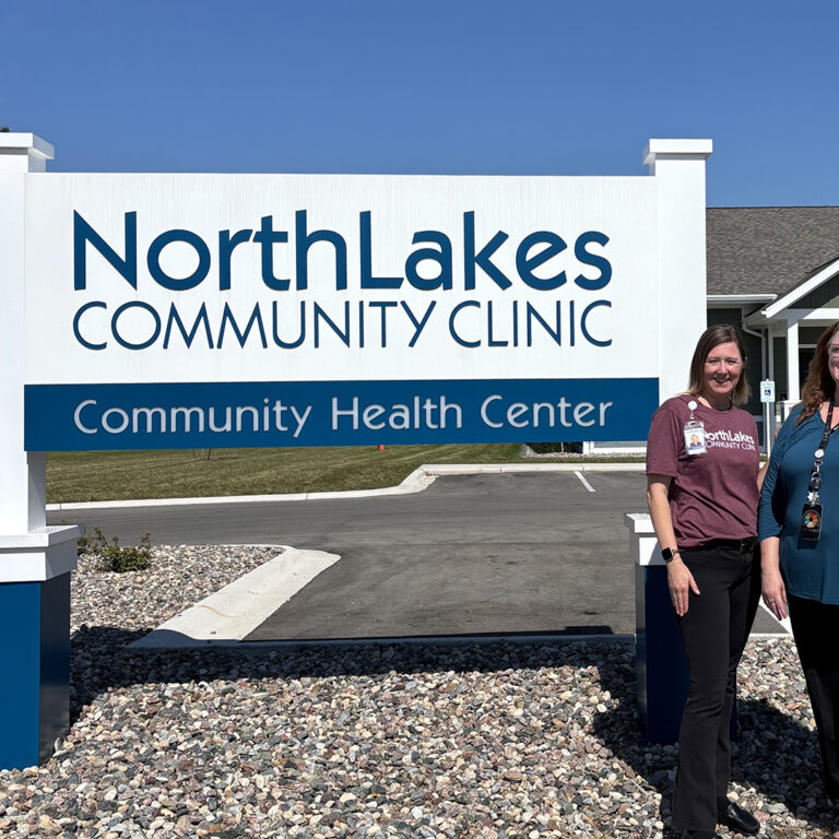 NorthLakes Oconto GGB three women in front of sign outside
