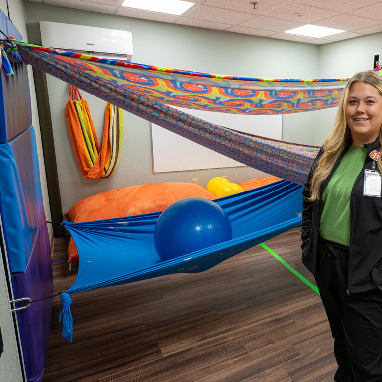 NorthLakes Sarah Wahlquist OT Woman in room with colorfull fabric draped behind