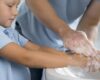 boy and adult washing hands