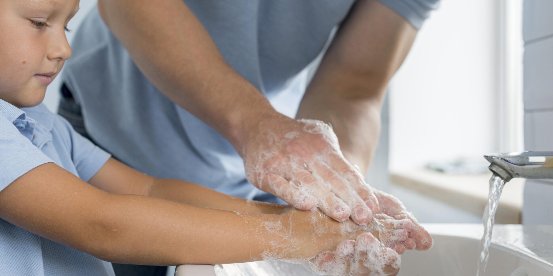 boy and adult washing hands