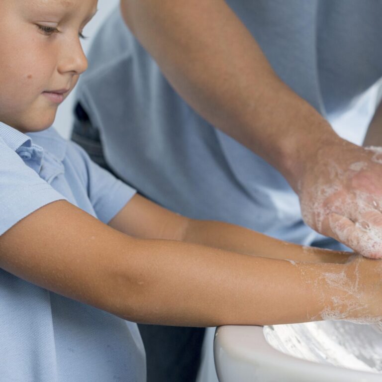 close-up-young-boy-washing-hands-with-father boy and adult washing hands