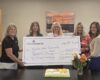 group of women holding large check