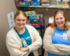 Two women smiling at camera with kid games behind them.