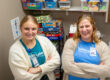 Two women smiling at camera with kid games behind them.